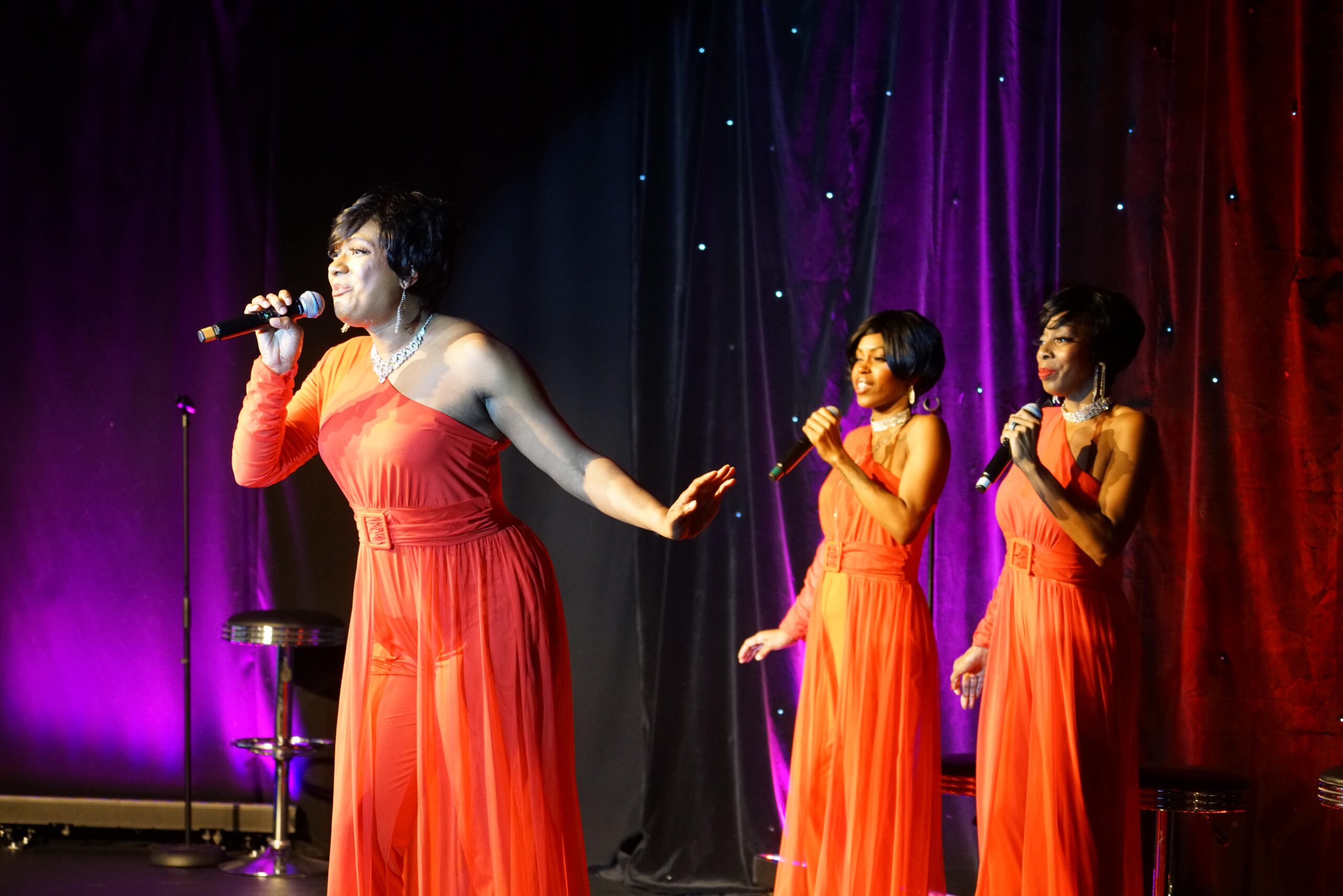 Motown Brunch lead singer in an orange gown with two backup singers at the Sunday Motown show in Las Vegas